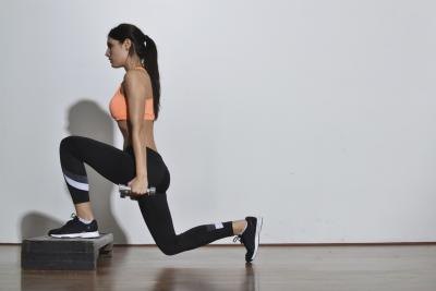 A woman doing weighted lunges.