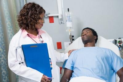 A doctor talks with a patient after a procedure. A doctor talks with a patient after a procedure.