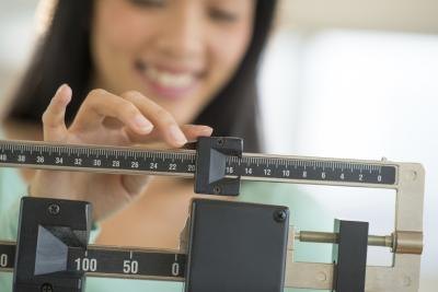 Woman measuring her weight Woman measuring her weight