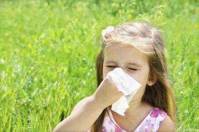A girl blows her nose outside.