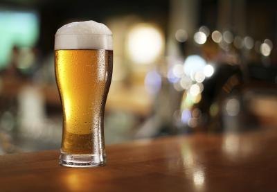 A pint of beer on a bar.