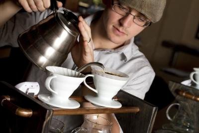 Barista brews unique coffee with filter in cup Barista brews unique coffee with filter in cup
