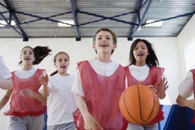 A group of preteens play basketball together. A group of preteens play basketball together.