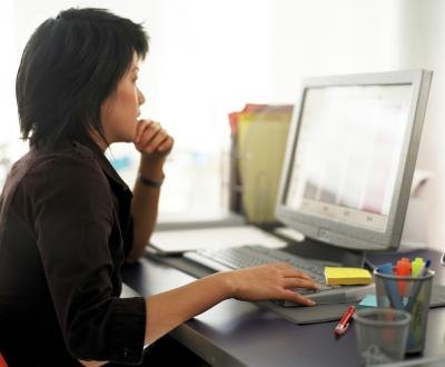 A woman analyzes data on a laptop.
