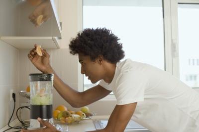 Man putting fruit in blender