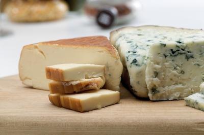 Wedges of cheese on a cutting board.