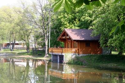 A quaint wooden cottage on a canal in the woods. A quaint wooden cottage on a canal in the woods.