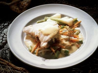 A cod fillet over a bed of vegetables. A cod fillet over a bed of vegetables.