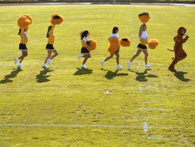 Tiger mascot being followed by cheerleaders