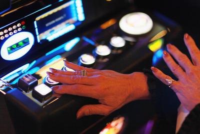 Hand of woman touching button on slot machine