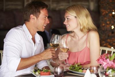 Couple toasting with white wine at restaurant