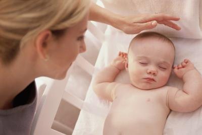 Mother putting Baby to Sleep on Stomach Mother putting Baby to Sleep on Stomach