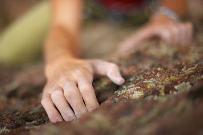 A woman climbs a rock face.