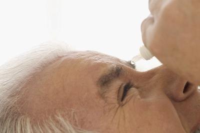man using eye drops