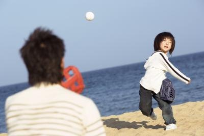 Young boy throwing baseball to father