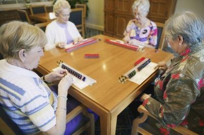 group of four people playing Mahjong