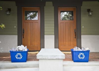 Recycling bins sit outside two homes.