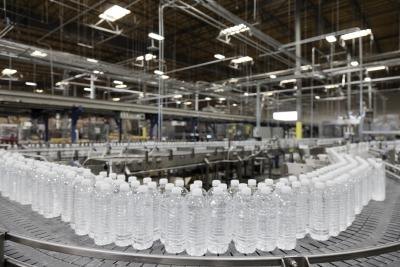 Factory line of water bottles on conveyor belt.