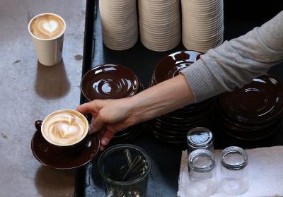 Barista serving drink with "latte art" to customer