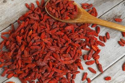 A heap of goji berries on a wooden surface