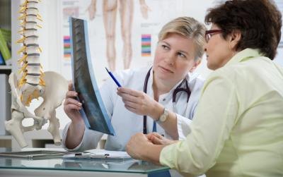 A patient discusses her degenerative disc disease diagnosis with her doctor. A patient discusses her degenerative disc disease diagnosis with her doctor.