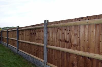 Fence with wooden slats and concrete posts