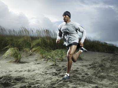 Muscular man running on the beach