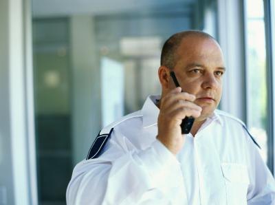Security guard talking on a walkie talkie.