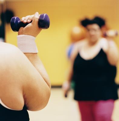 A woman does weight training at a gym.
