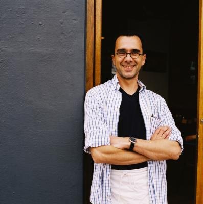 A server stands at the front door of an establishment.