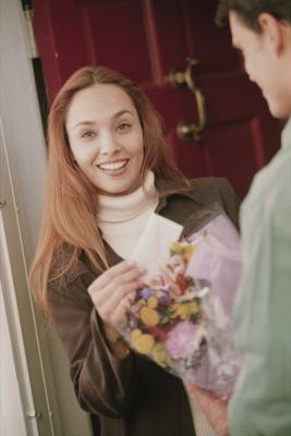 Woman receiving flowers from delivery man