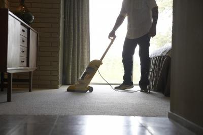 Man vacuuming bedroom
