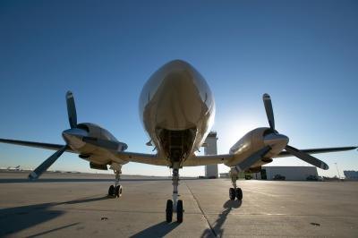 A multi-prop plane sits on a runway.