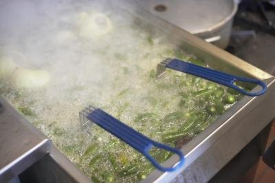 Green chilies being fried in oil cooker