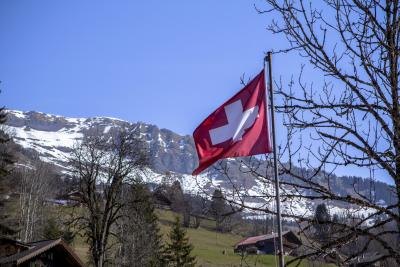 Swiss flag waving in Switzerland landscape