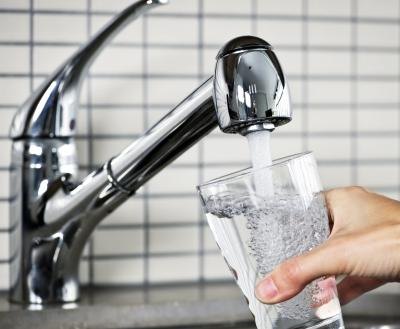A woman gets water from the faucet.