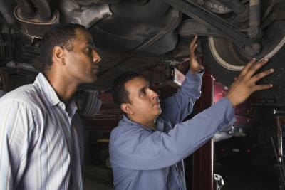Mechanic and car owner looking at tire