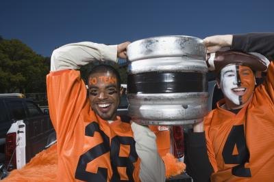 Men carrying a beer keg at football game Men carrying a beer keg at football game