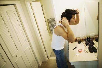 Man styling his hair in bathroom Man styling his hair in bathroom