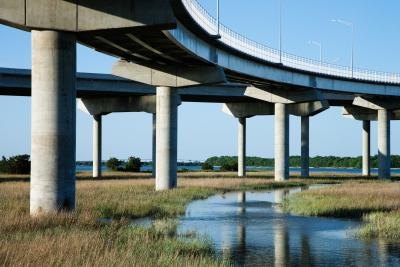 Cement pillars support a highway over wetlands.