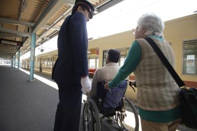 A train conductor assisting passengers.
