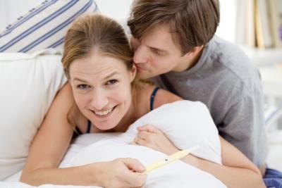 smiling couple holding pregnancy test smiling couple holding pregnancy test