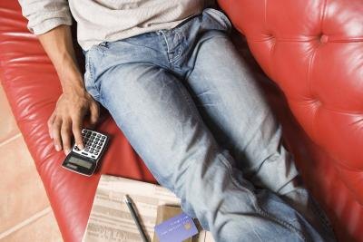 Man using calculator on couch