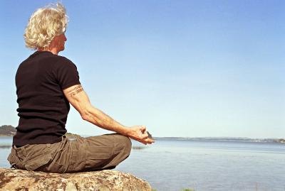 man meditating on rock