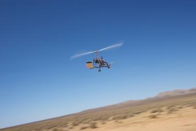 An ultralight flies over the desert.