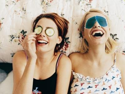 Teenage girls laughing on bed