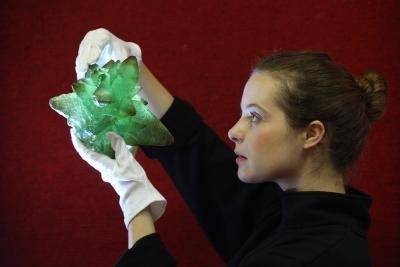 An art handler holds up a piece of kryptonite, a prop used in a Superman film, at an auction.