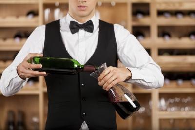 Waiter in tuxedo pouring wine
