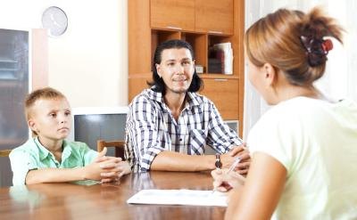 Social worker speaking with young child and foster parent