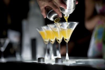 Bartender pours cocktails at a nightclub bar.